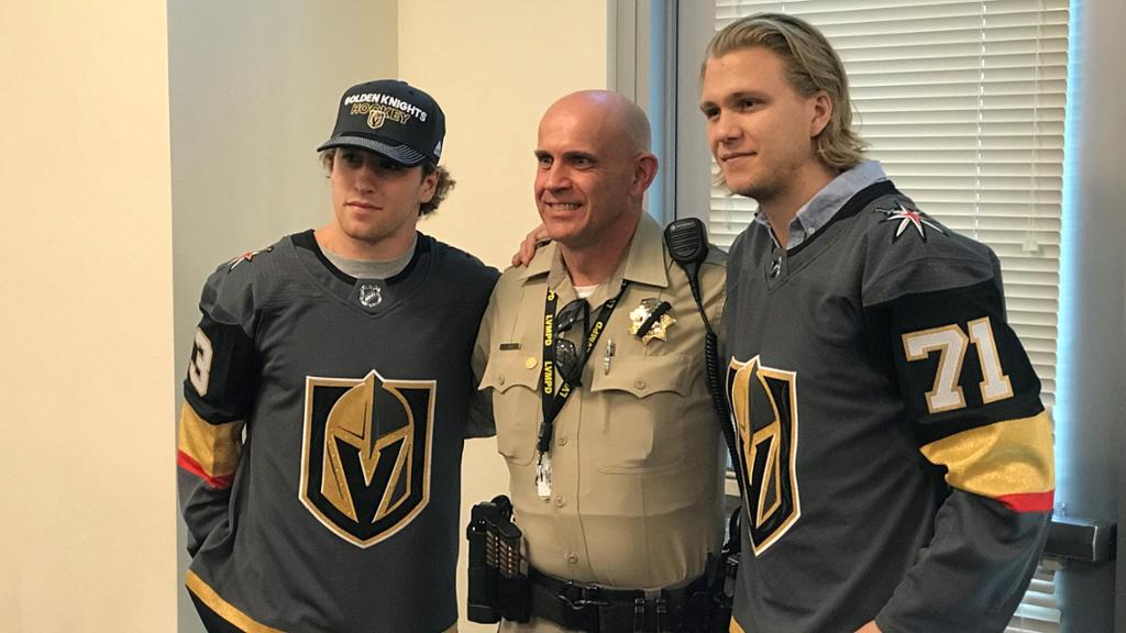 Two Vegas Golden Knights players pose with a member of the Las Vegas Metropolitan Police Department after October 1 tragedy